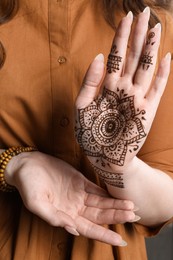 Photo of Woman with beautiful henna tattoo on hand, closeup. Traditional mehndi