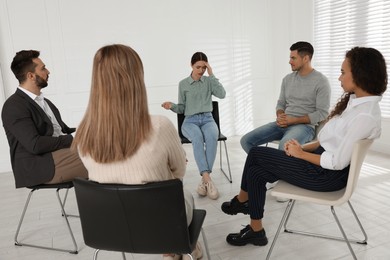 Photo of Psychotherapist working with patients at group session indoors