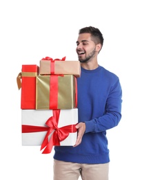 Happy young man holding Christmas gifts on white background