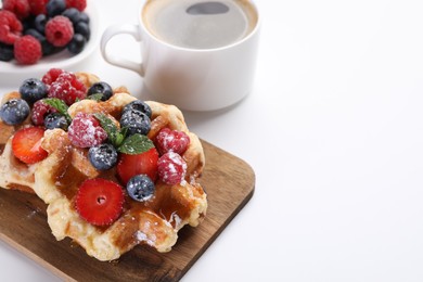 Photo of Delicious Belgian waffles with fresh berries on white table, space for text