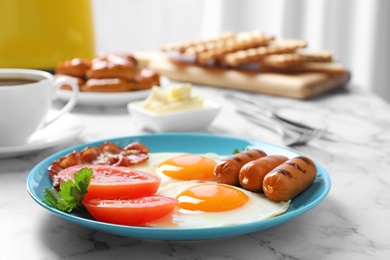 Photo of Plate with traditional English breakfast on marble table