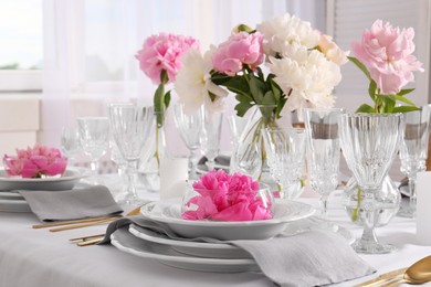 Stylish table setting with beautiful peonies in dining room