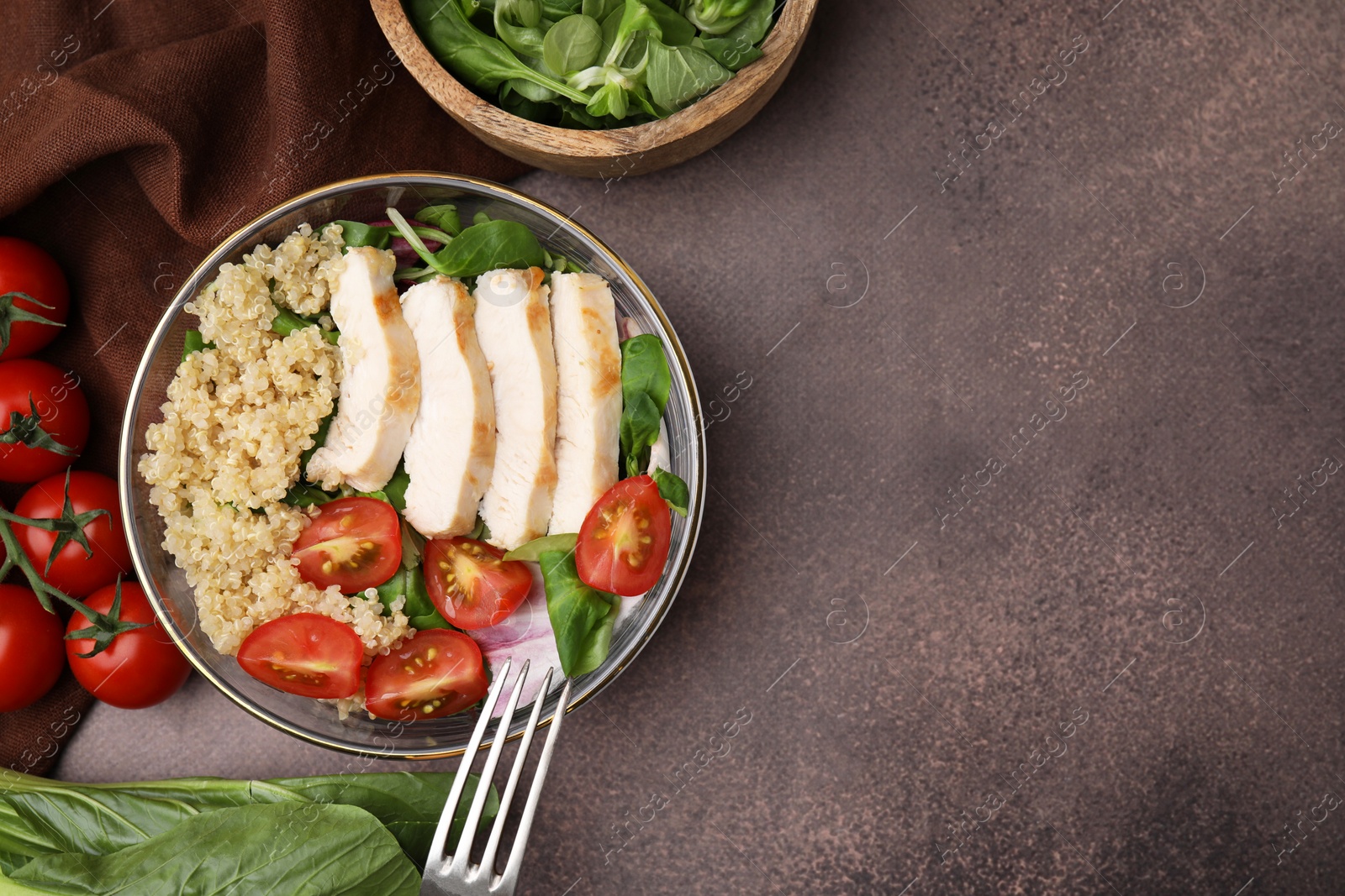 Photo of Delicious quinoa salad with chicken and cherry tomatoes served on grey textured table, flat lay. Space for text
