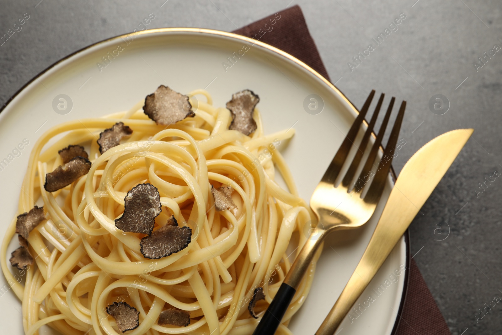Photo of Tasty fettuccine with truffle on grey table, top view