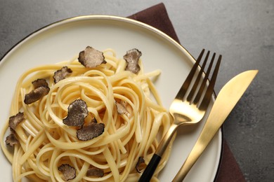 Tasty fettuccine with truffle on grey table, top view