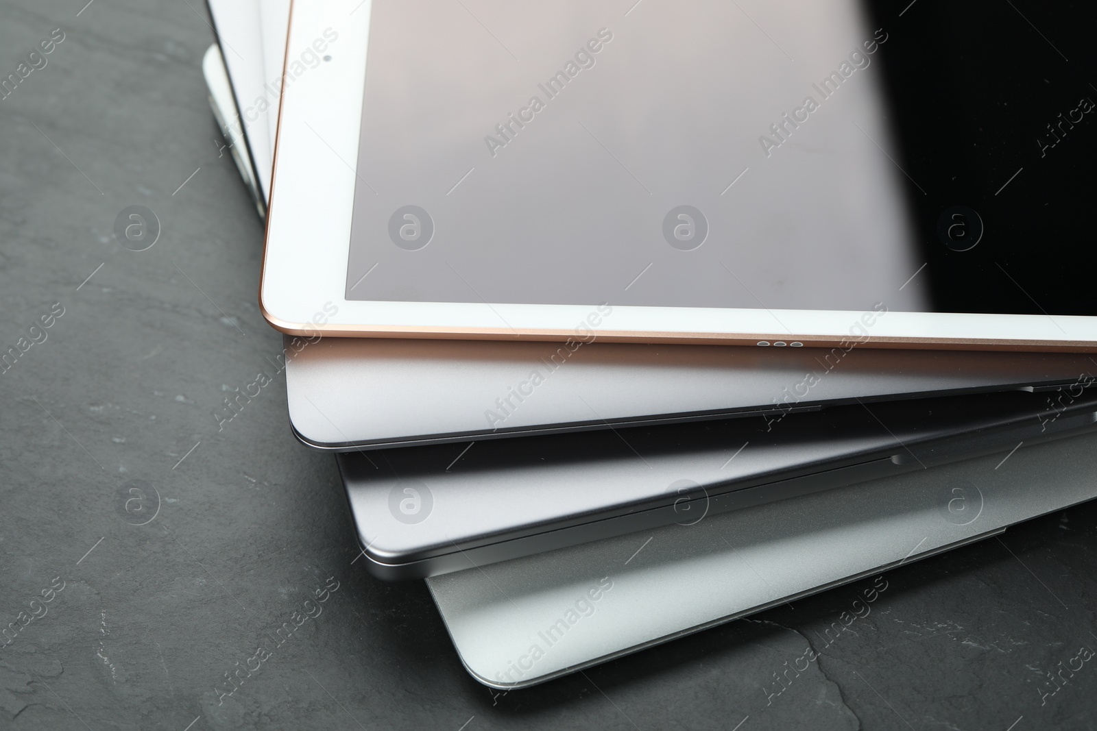 Photo of Stack of electronic devices on black table, closeup