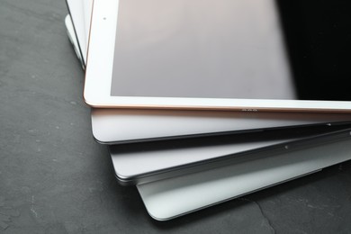 Stack of electronic devices on black table, closeup