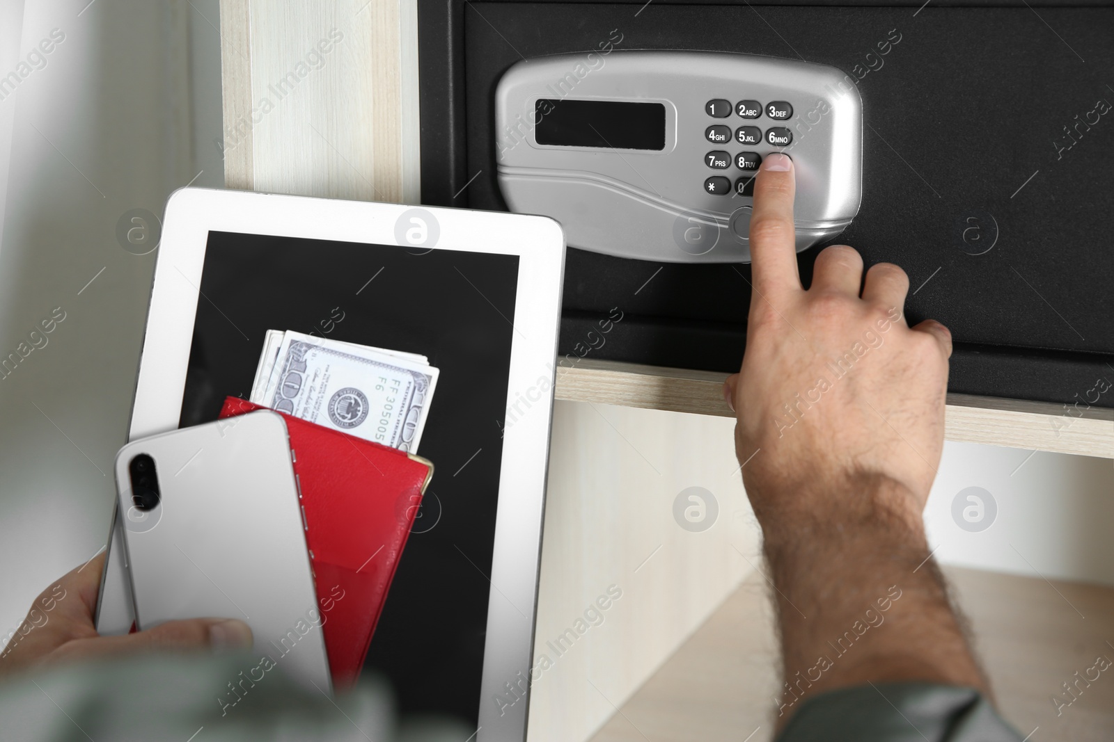 Photo of Man opening steel safe with electronic lock at hotel, closeup