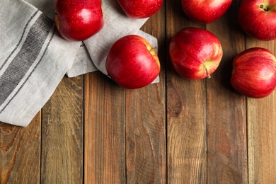 Photo of Ripe red apples on wooden table, flat lay. Space for text