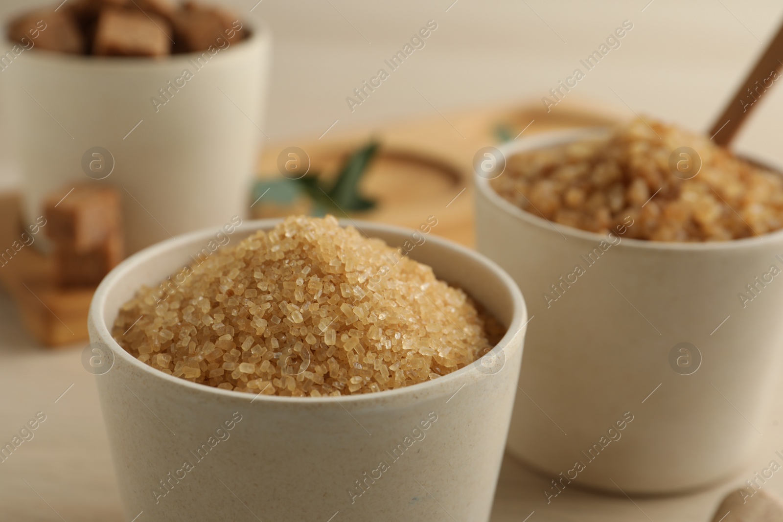 Photo of Brown sugar in bowl on wooden table, closeup