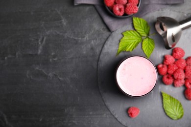 Glass of tasty raspberry smoothie on dark marble table, flat lay. Space for text