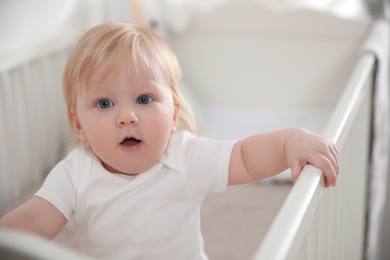 Photo of Cute little baby in crib at home