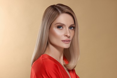 Portrait of stylish attractive woman with blonde hair on dark beige background