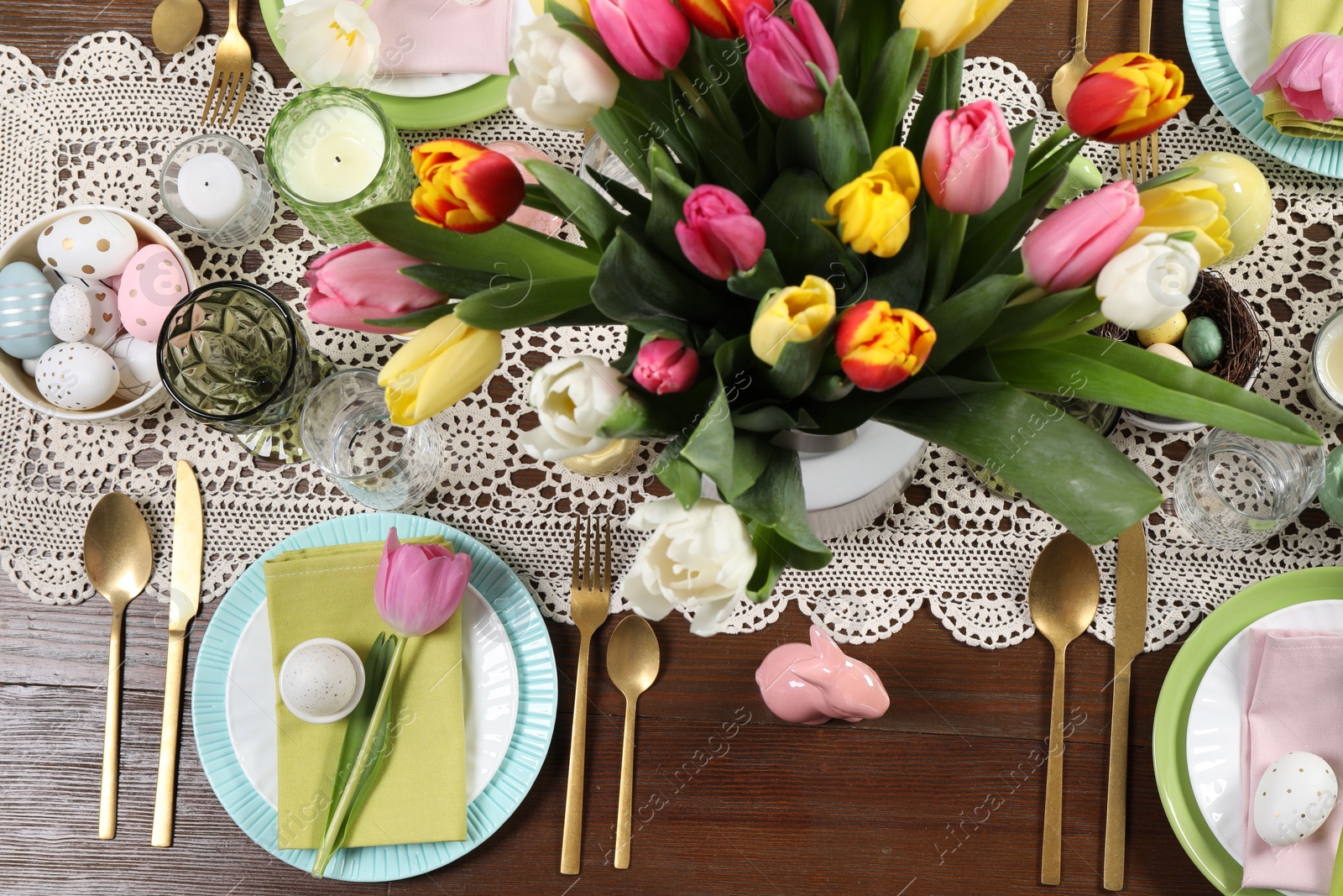 Photo of Festive table setting with beautiful flowers, flat lay. Easter celebration