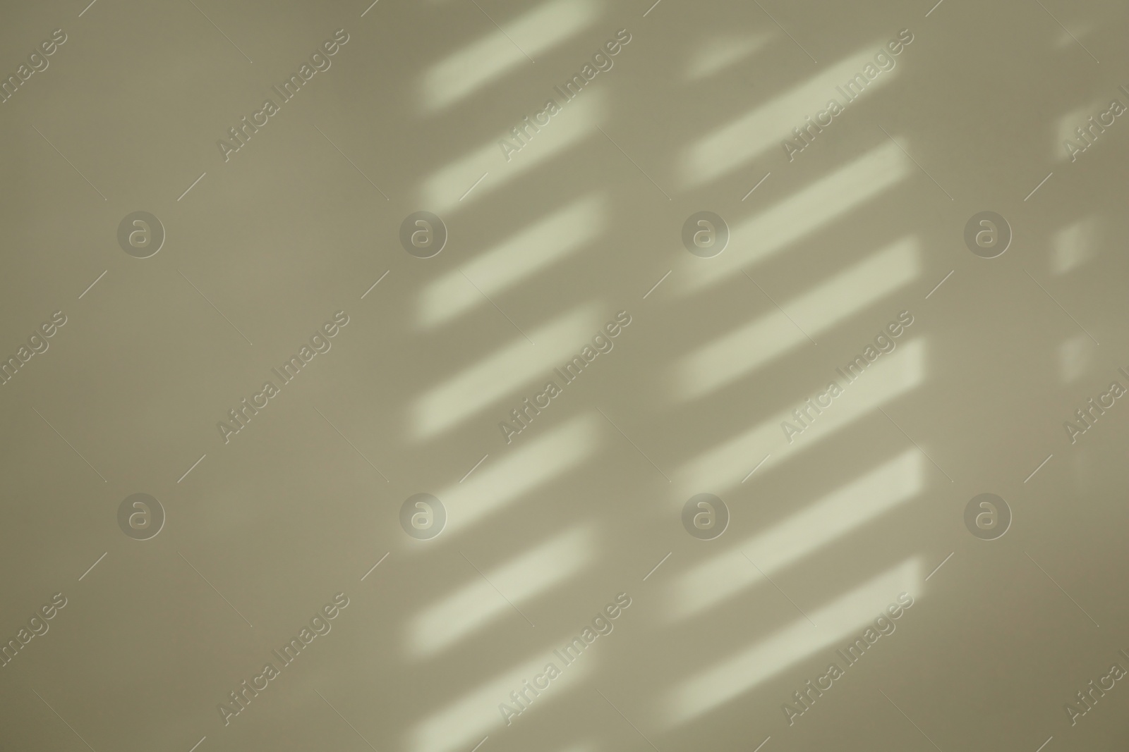 Photo of Light and shadow from window on beige wall indoors