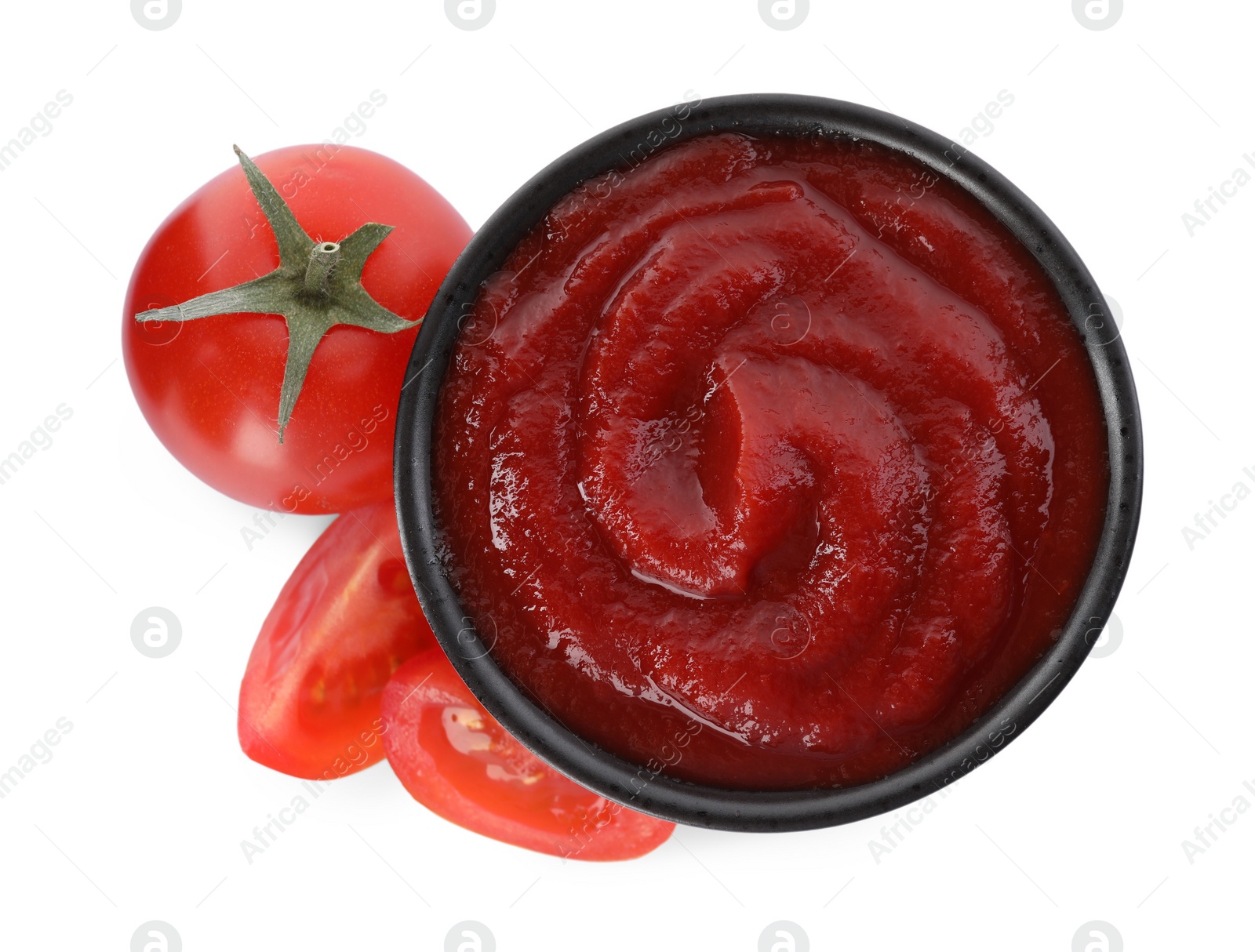 Photo of Tasty ketchup in bowl and fresh tomatoes isolated on white, top view