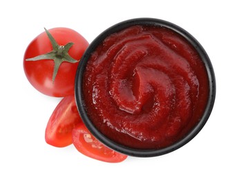 Photo of Tasty ketchup in bowl and fresh tomatoes isolated on white, top view