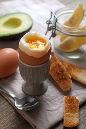 Photo of Soft boiled egg served for breakfast on wooden table