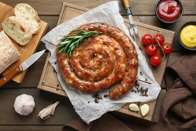 Delicious homemade sausage with spices served on wooden table, flat lay