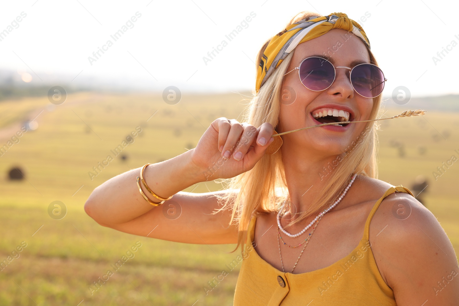 Photo of Beautiful happy hippie woman with spikelet in field