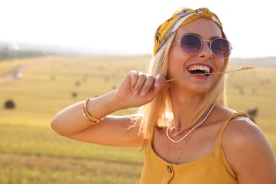 Photo of Beautiful happy hippie woman with spikelet in field