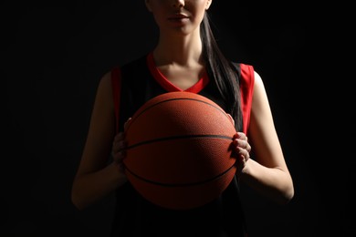 Basketball player with ball on black background, closeup