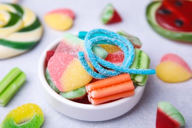 Bowl of tasty colorful jelly candies on white table, closeup