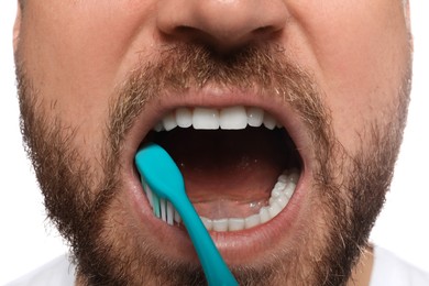 Man brushing teeth on white background, closeup. Dental care