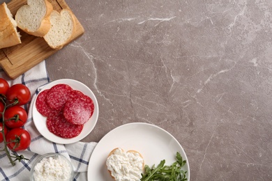 Photo of Delicious bruschetta with cheese and products on grey table, flat lay. Space for text