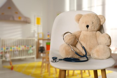Image of Teddy bear with stethoscope on chair indoors, space for text. Pediatrician practice
