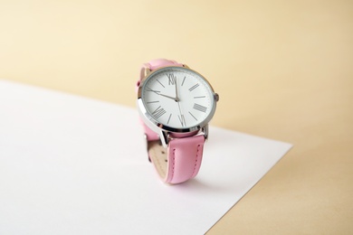 Photo of Stylish wrist watch on color background. Fashion accessory