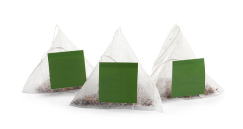 Photo of New pyramid tea bags on white background