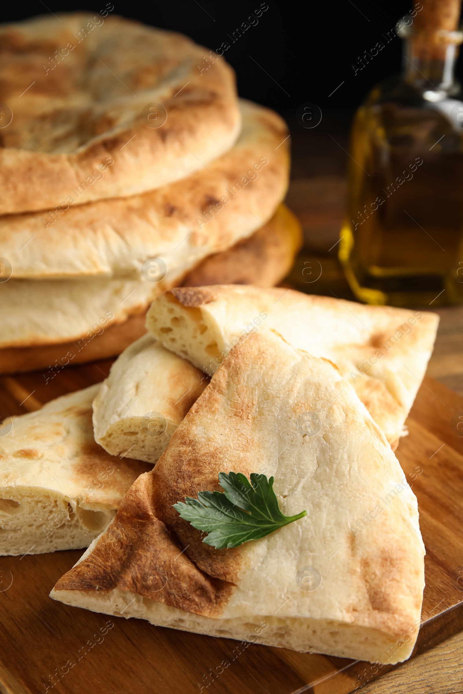 Photo of Cut fresh pita bread on wooden table, closeup