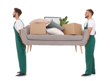 Young workers carrying sofa with stuff isolated on white. Moving service