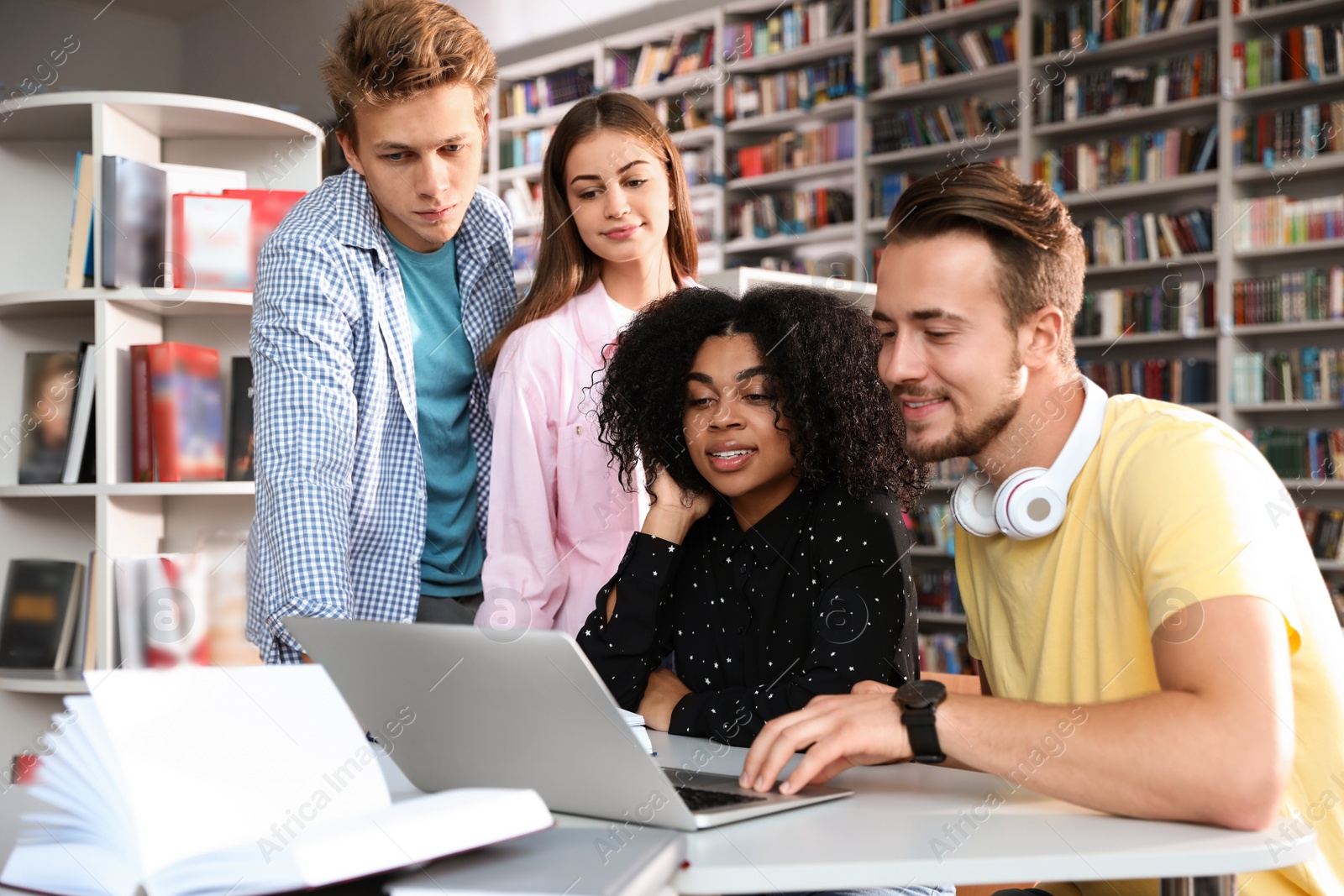 Photo of Group of young people studying at table in library