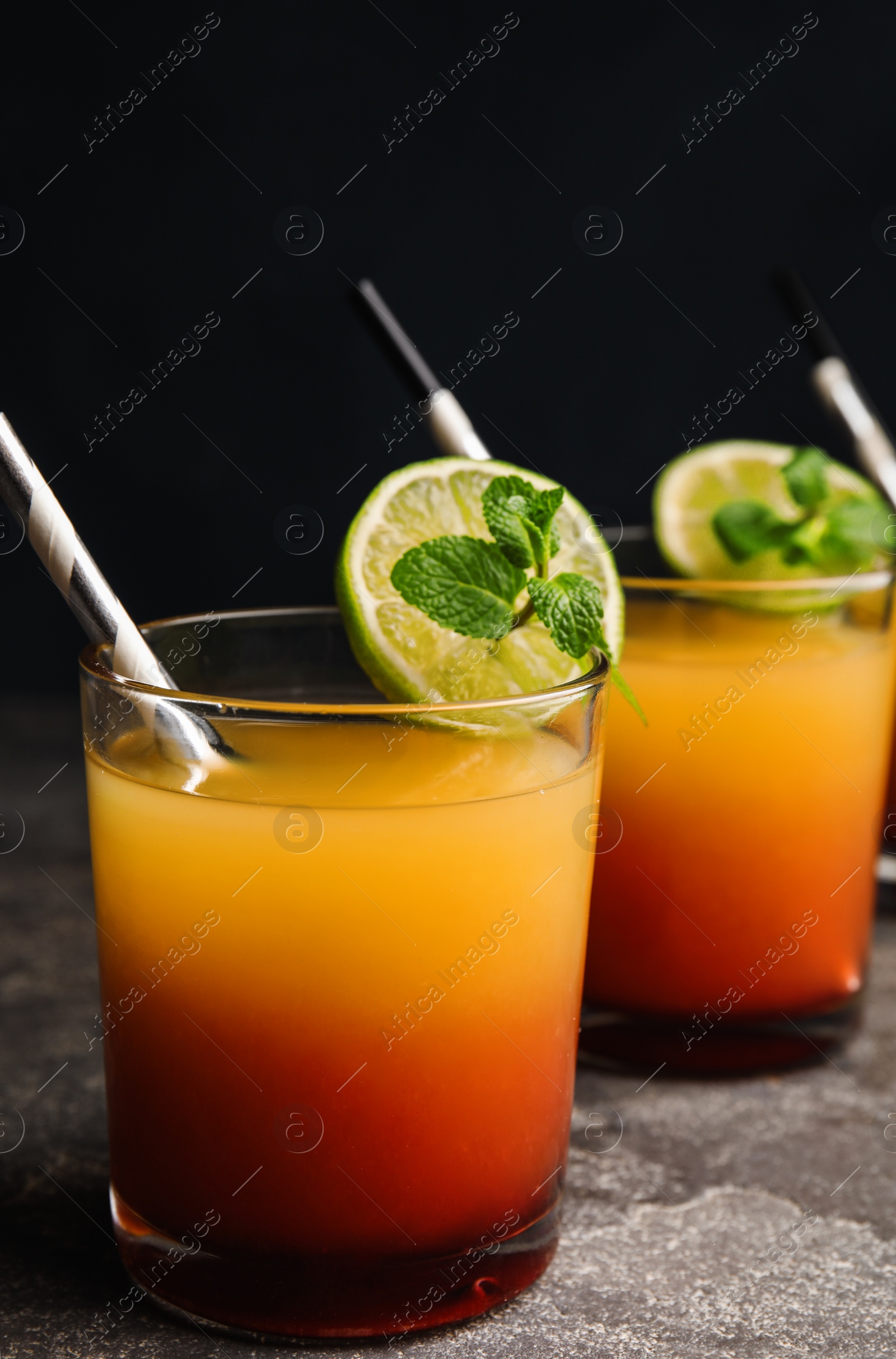 Photo of Fresh alcoholic Tequila Sunrise cocktail on grey table