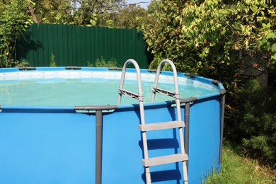 Above ground swimming pool on grass in backyard