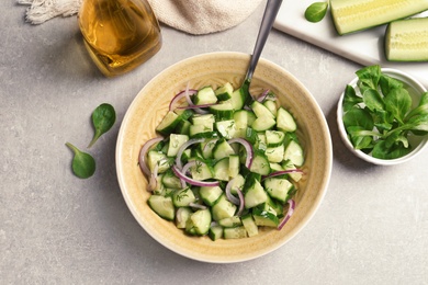 Photo of Plate with tasty cucumber salad served on table, top view