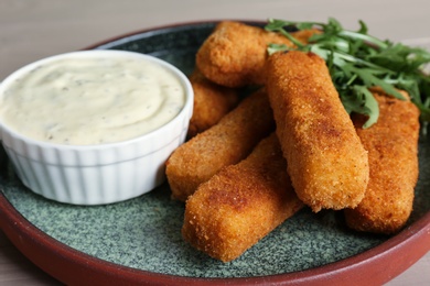 Photo of Plate of tasty cheese sticks and sauce, closeup