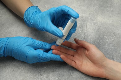 Photo of Diabetes. glucose testing. Doctor using lancet pen at light table, closeup