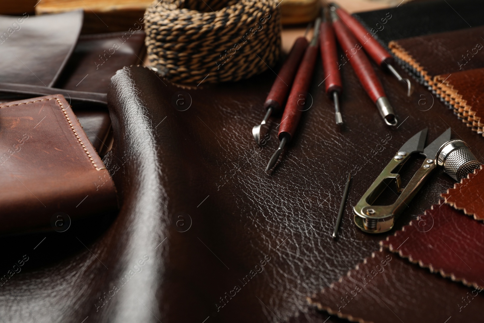 Photo of Leather samples and tools as background, closeup