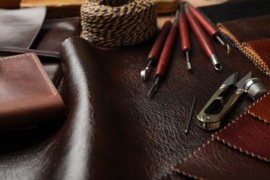 Photo of Leather samples and tools as background, closeup