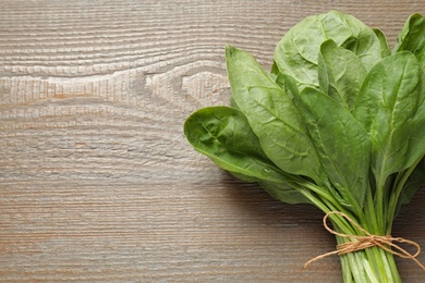 Photo of Bunch of fresh green healthy spinach on wooden table, top view. Space for text