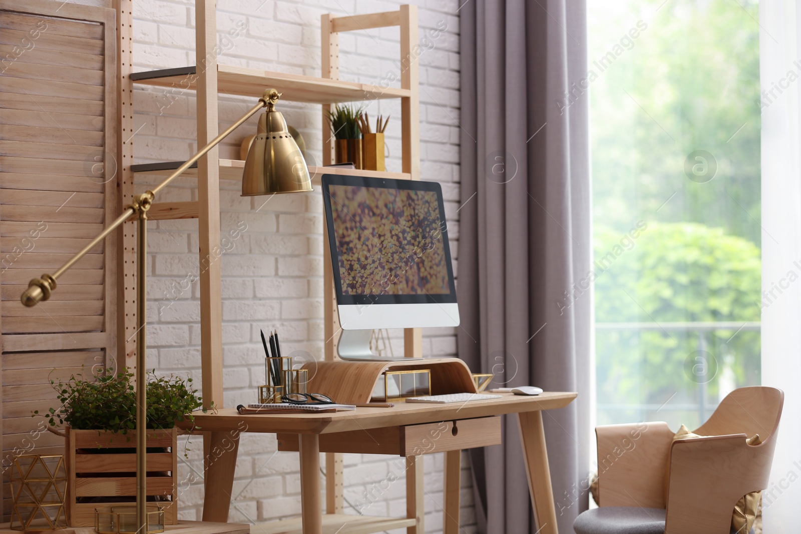 Photo of Stylish room interior with modern workplace at brick wall