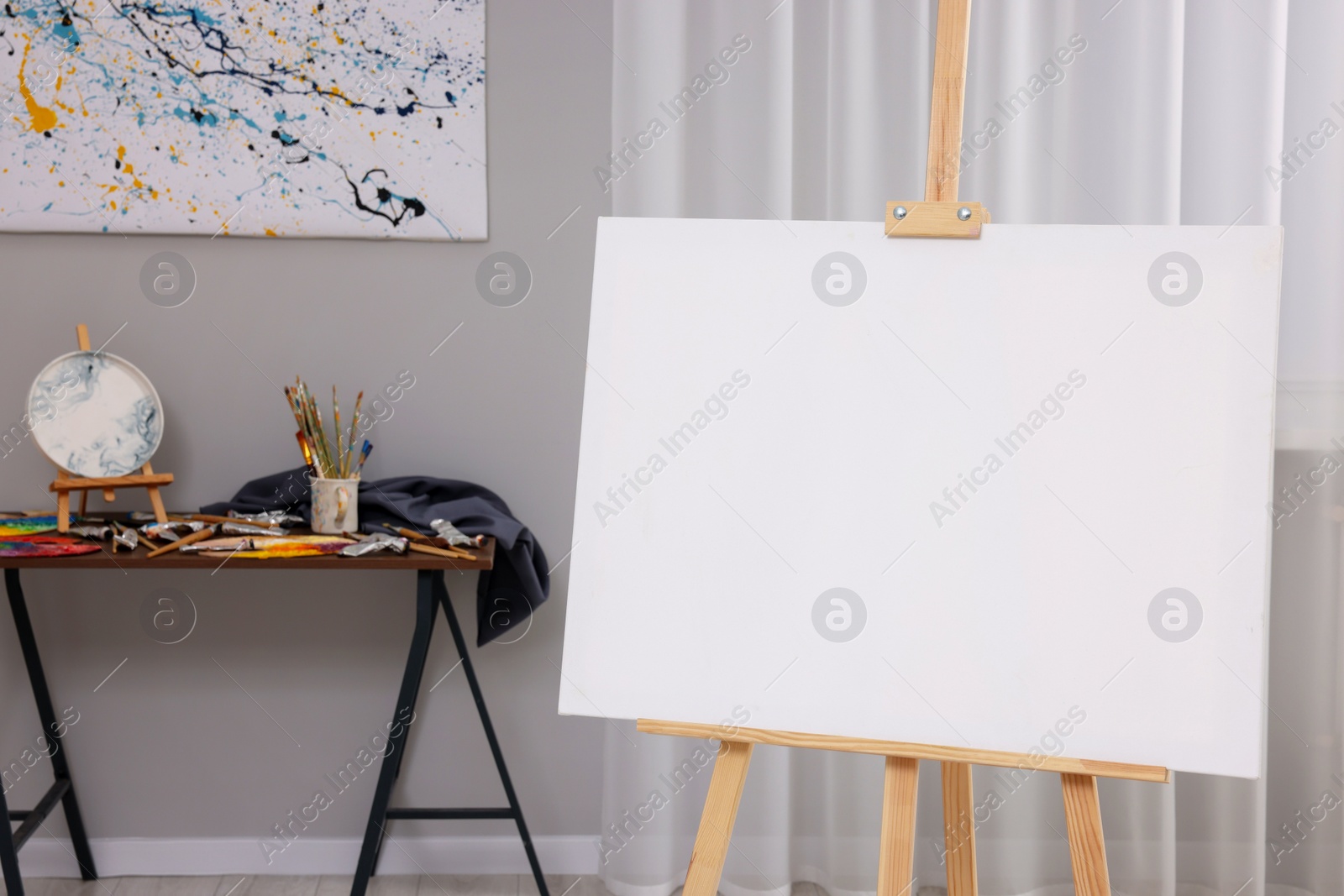 Photo of Wooden easel with canvas in artist's studio