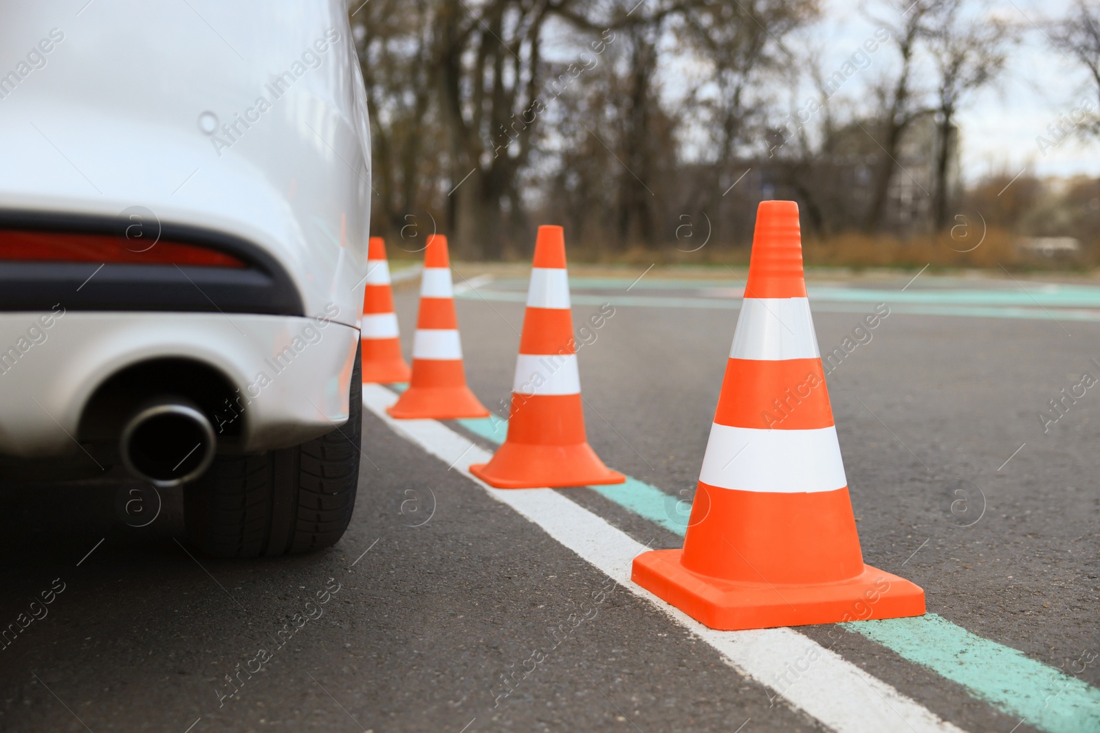 Photo of Modern car on test track with traffic cones, closeup. Driving school