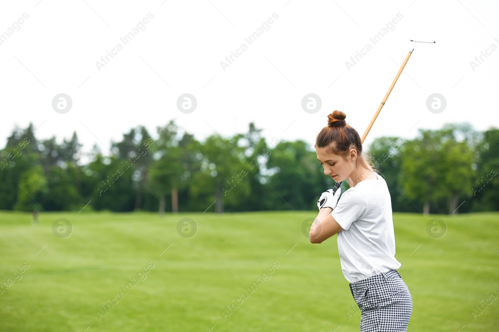 Photo of Woman playing golf on green course. Sport and leisure