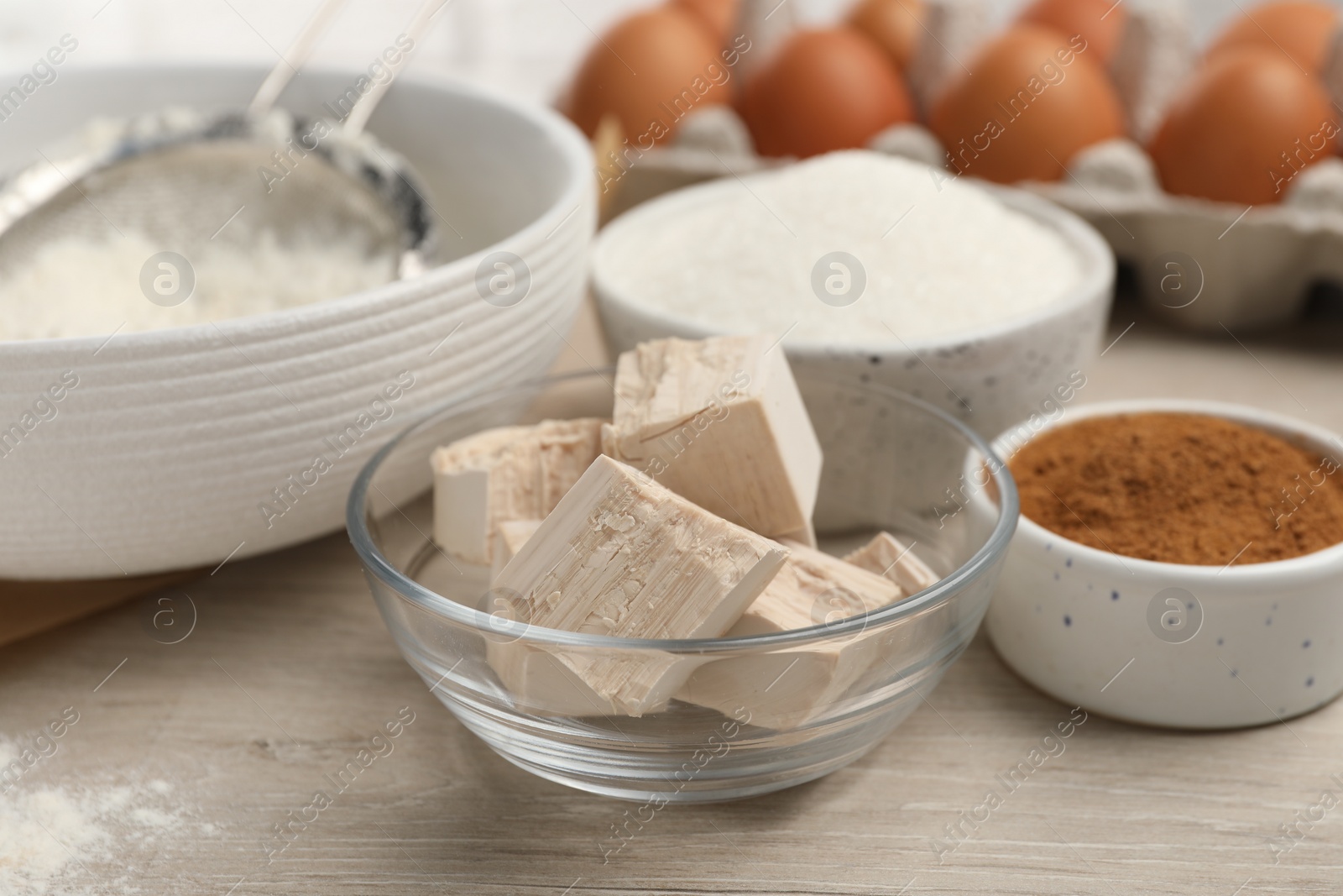 Photo of Flour, leaven and different ingredients on white wooden table. Cooking yeast cake