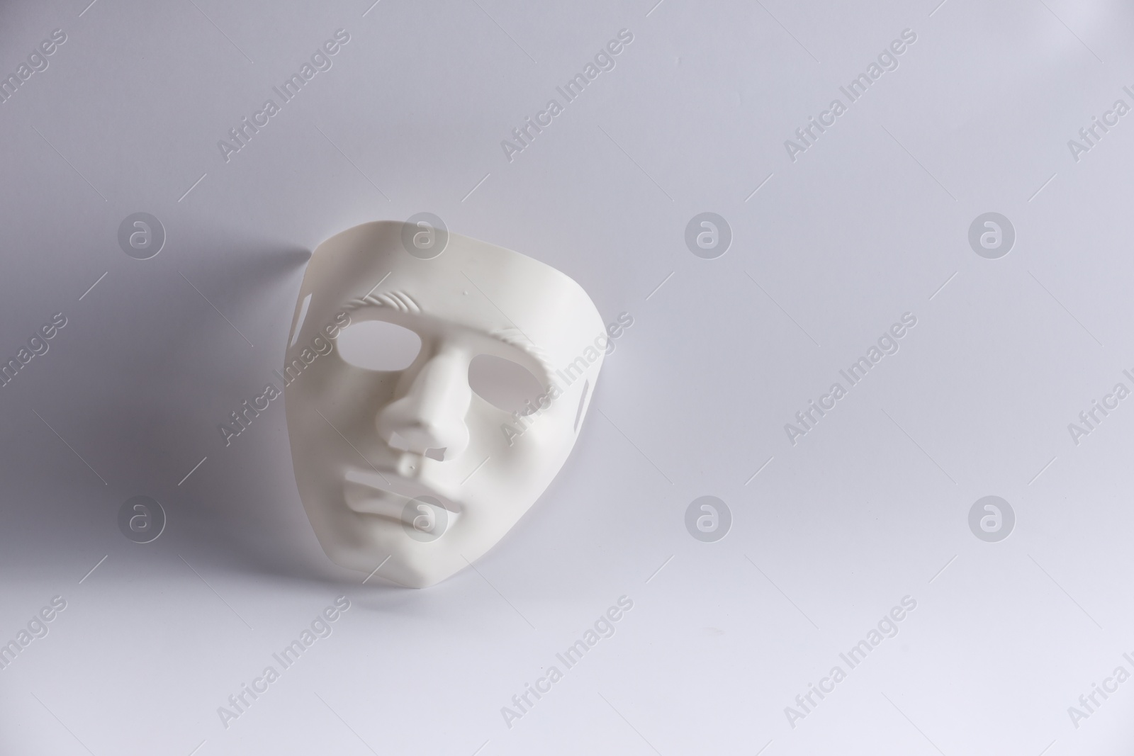 Photo of Plastic face mask on white background, space for text. Theatrical performance