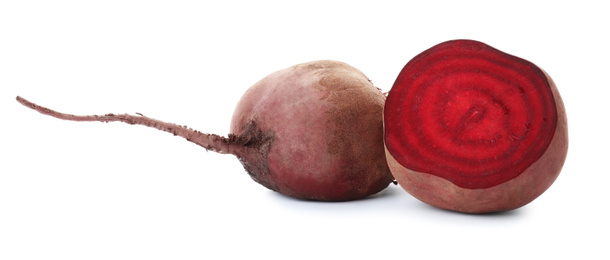 Whole and cut red beets on white background